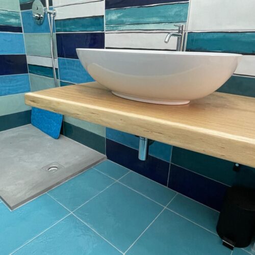un bagno con piastrelle blu e lavabo bianco.