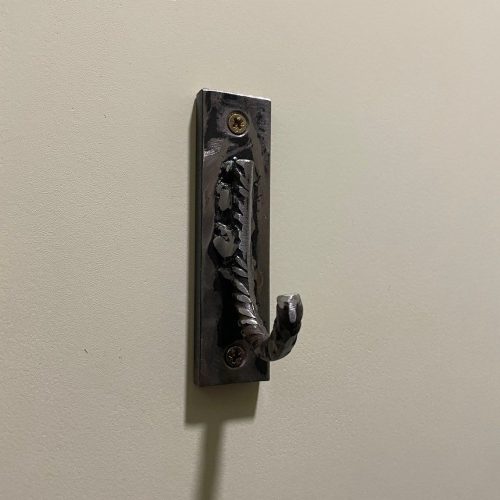 una maniglia della porta di metallo su un muro bianco.